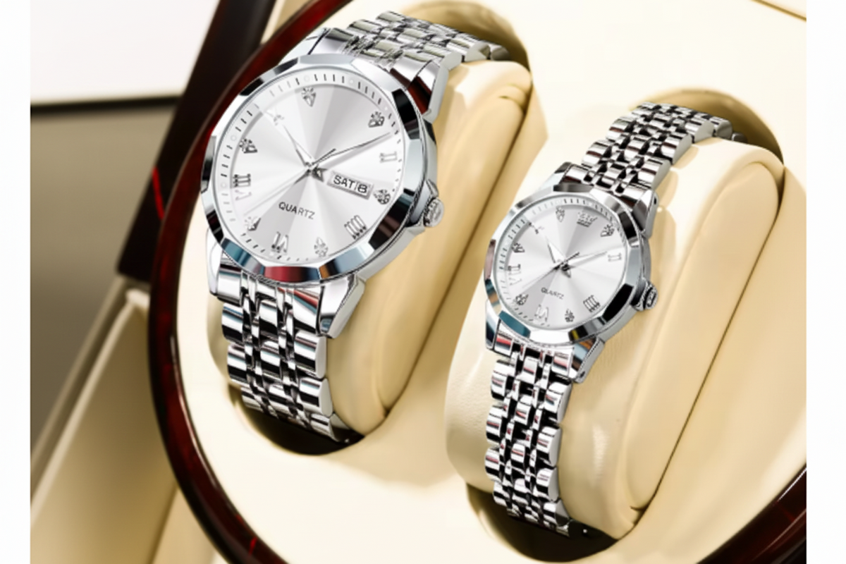 Two silver stainless steel wristwatches with white dials and link bracelets, displayed on beige cushioned stands. A red OLEVS logo badge is visible in the top-left corner.