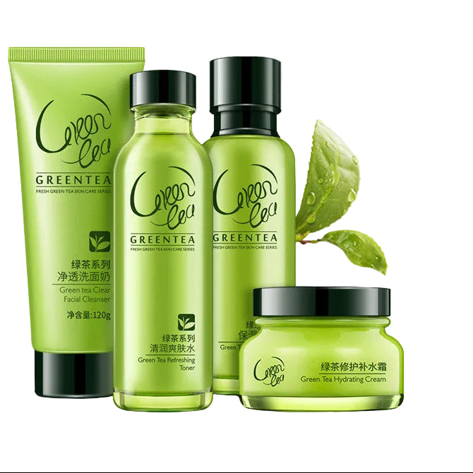 Four Green Tea series skincare products from the brand 'Green Tea' arranged together on a light green reflective surface with floating bubbles and tea leaf graphics. The set includes a squeeze tube, two pump bottles, and a jar, all in translucent green with black caps.