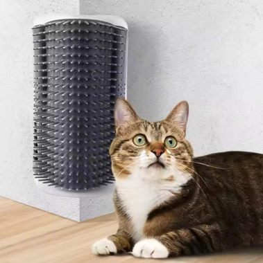 Cat lying on a wooden floor next to a cylindrical pet product against a light gray wall.