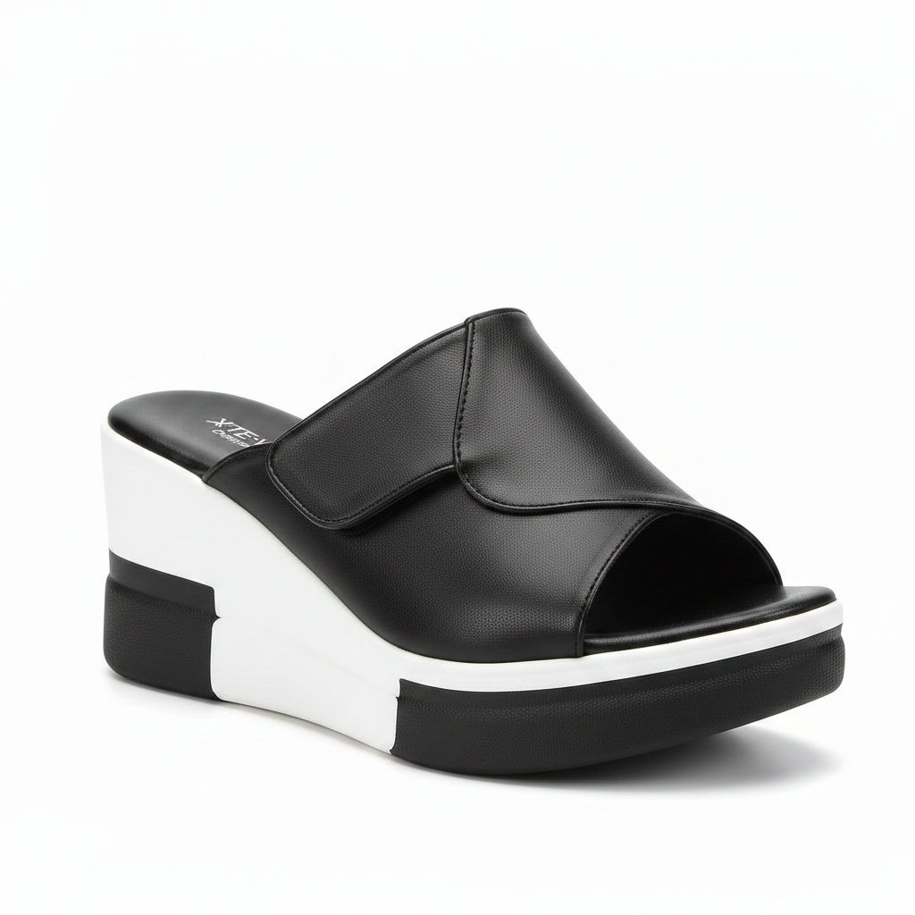 Black platform slide sandals with a thick white sole, shown being worn on one foot and held in a hand. The brand name 'Royal Ste.