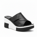 Black platform slide sandals with a thick white sole, shown being worn on one foot and held in a hand. The brand name 'Royal Ste.