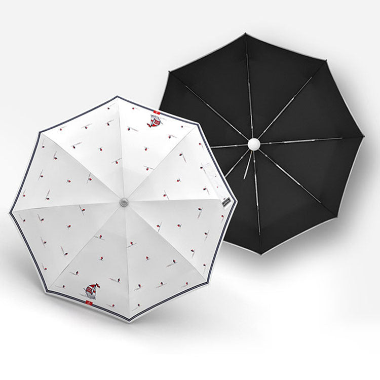 Two umbrellas, one white with red patterns and one black, on a light gray background.