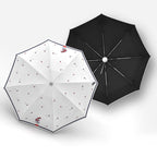 Two umbrellas, one white with red patterns and one black, on a light gray background.
