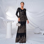 Woman in a black and gold sequin dress standing against a white draped curtain.