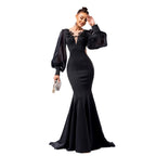 Woman wearing a black evening gown with sheer sleeves on a white background