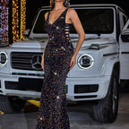 Woman in a sparkling black dress standing next to a white Mercedes-Benz G-Class SUV.