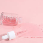 Serum bottle with dropper on a pink background, highlighting 'Silky Texture and Clear Skin Feel' features.