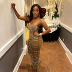 Woman in a sparkling evening gown standing in an elegant room with decorative elements.