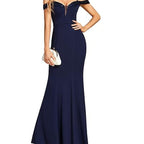 Navy blue evening gown with a white clutch on a white background