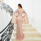 Woman in a pink sequin dress standing on a staircase