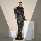 Woman in a black sequin gown standing on a white pedestal against a neutral background