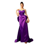 Woman wearing a purple evening gown with a neutral background