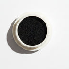 Black nail polish with a brush and striped nails on a white background