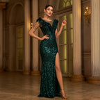 Woman in a green sequin dress posing in an elegant interior setting