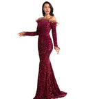 Woman wearing a burgundy sequin gown against a white background