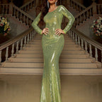 Woman in a green sequin dress standing on a staircase