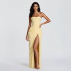 Yellow strapless gown with a high slit on a white background
