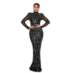 Woman wearing a black sequin gown standing against a neutral background