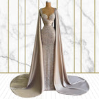 Elegant evening gown with a cape on a mannequin against a marble background