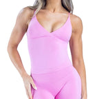 Person wearing a pink sleeveless top on a light blue background
