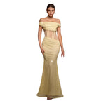 Woman wearing a gold off-shoulder evening gown in a misty setting
