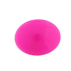 Pink silicone coaster on a white surface with a blurred white mug in the background