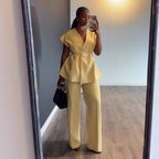 Woman in a yellow outfit taking a mirror selfie.