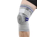Gray knee brace with blue accents on a person's knee against a white background