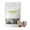 A white stand-up pouch labeled 'Herbal Detox Blend Tea' with a clear window showing loose herbal tea inside, plus two small individual tea bags placed in front on a white background.