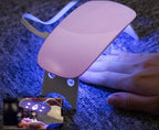 Foot with a small lamp emitting a blue light on a dark surface